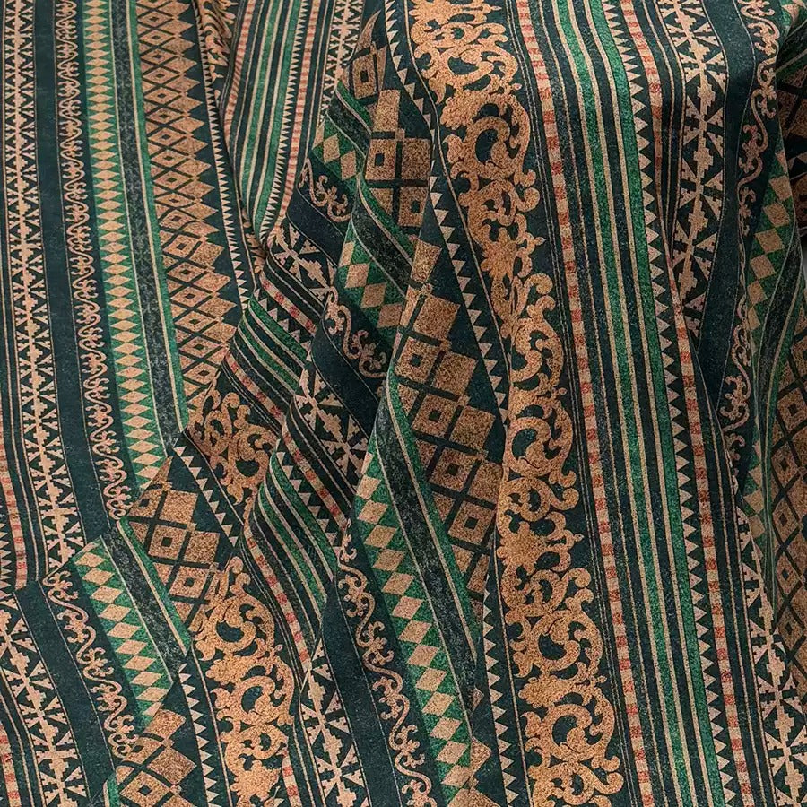 a close-up view of a fabric with a repeating pattern of geometric shapes and lines in shades of green, brown, and black. The pattern appears to be a textile design, possibly used for clothing or home decor.