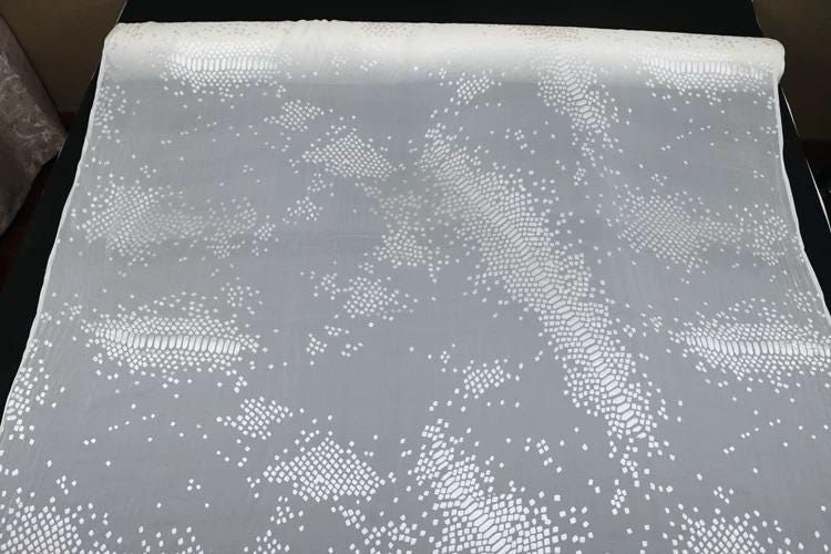 a close-up view of a white fabric with a pattern of small white dots or dots on it.