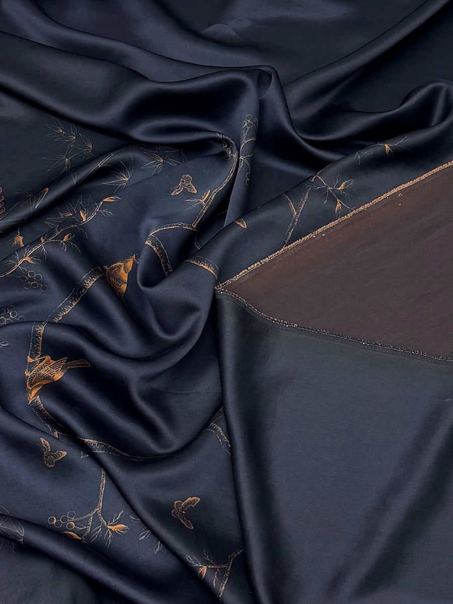 a close-up view of a dark blue fabric with a gold pattern, featuring a crumpled texture and a dark brown or black area on the right side.