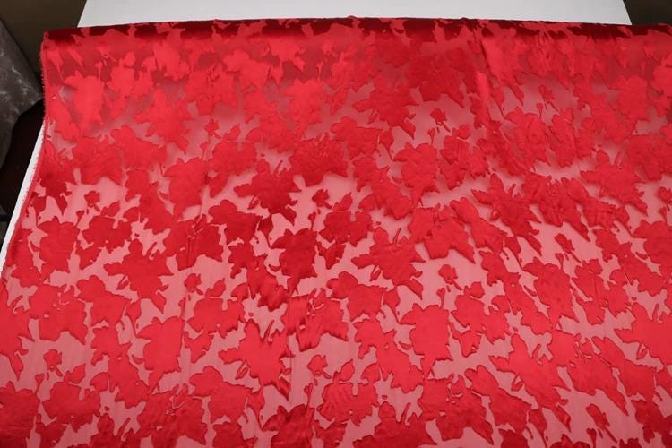 a red fabric with a leaf pattern, covering a large surface area.