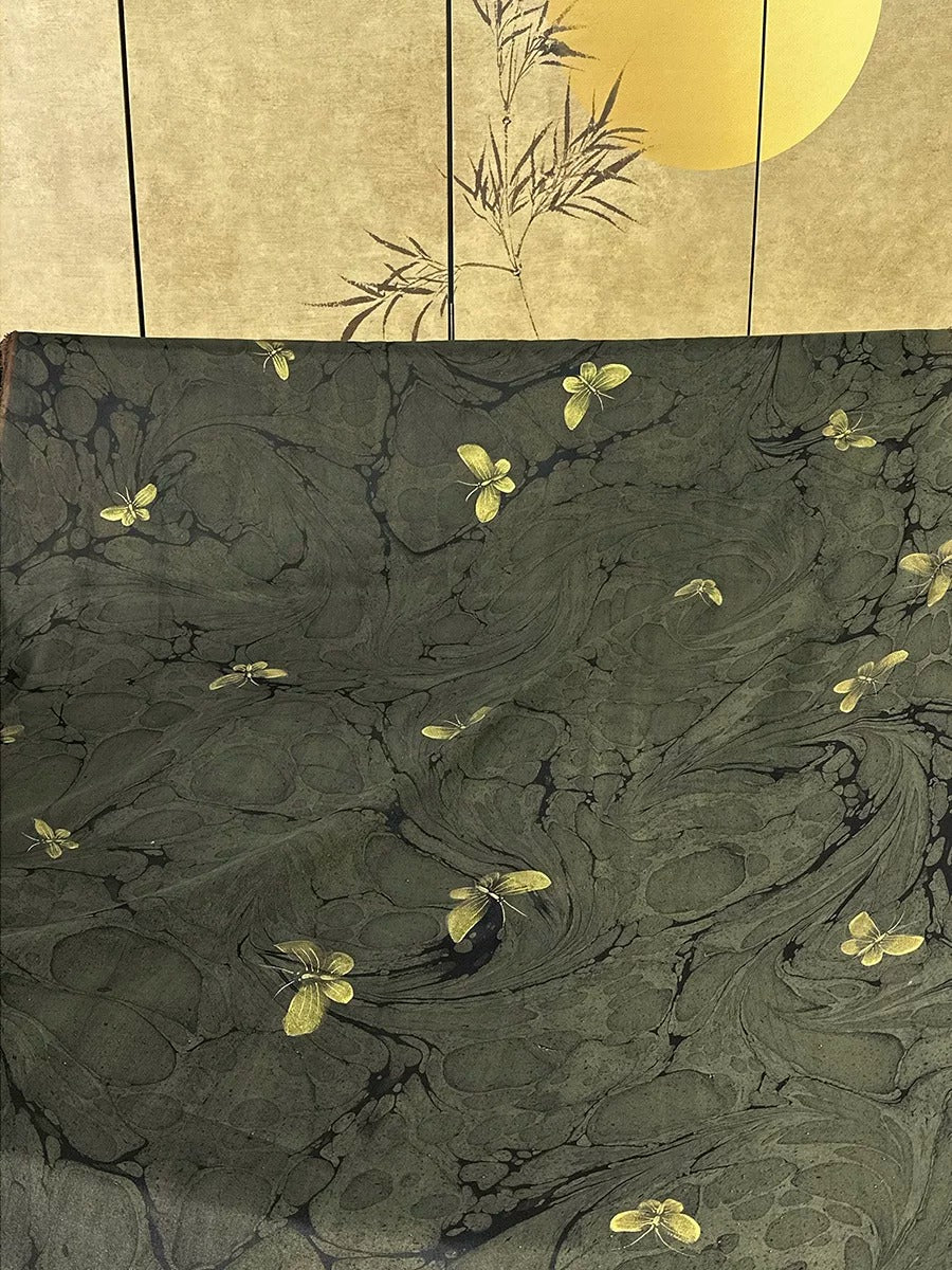 The image is a collage featuring a dark green marble-like background with yellow butterflies scattered across it.