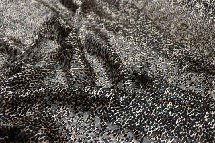 a close-up view of a fabric with a distinctive black and white spotted pattern.
