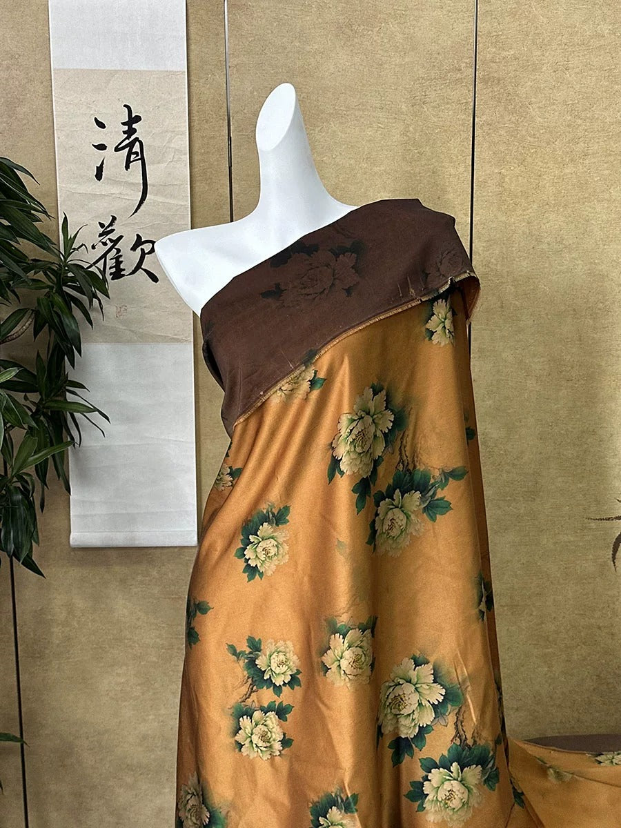 A mannequin wearing a brown and gold floral dress stands in front of a wall with a Chinese banner.