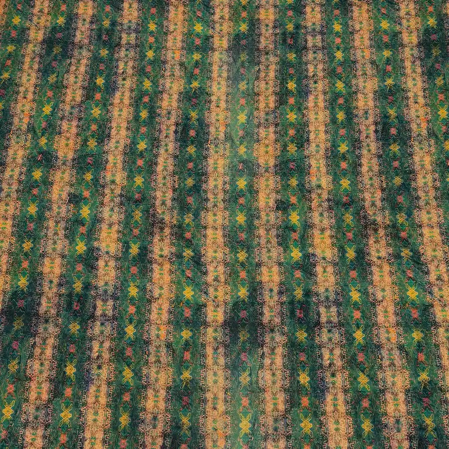 a vibrant, colorful pattern with a repeating diagonal line design in shades of green, yellow, and orange. The pattern appears to be a textile or fabric with a geometric, abstract design.