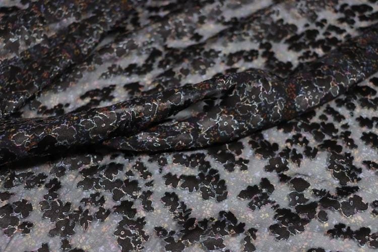 a close-up view of a fabric with a black and white floral pattern.