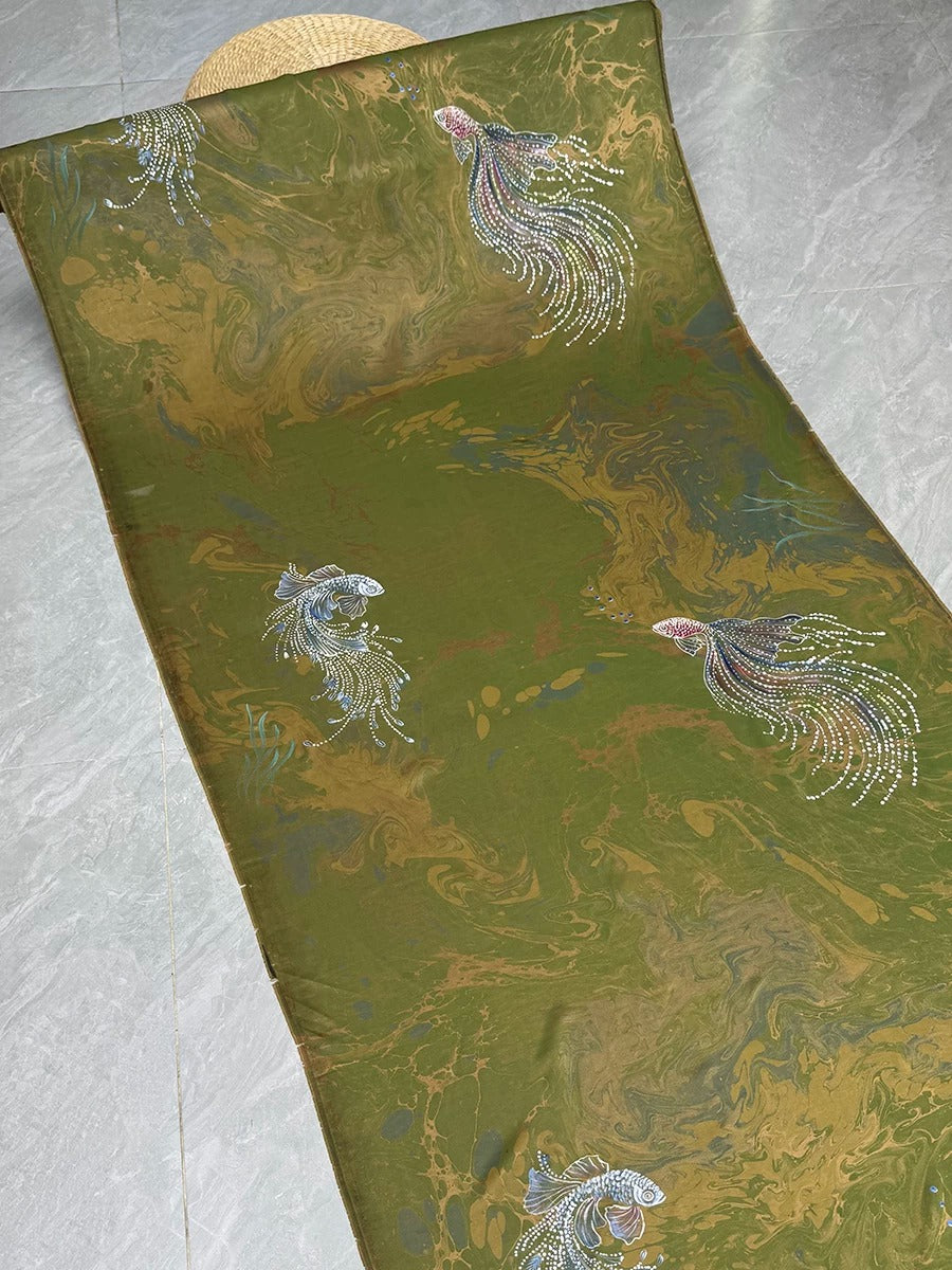 a green and gold patterned fabric with a repeating design of fish and other aquatic creatures.