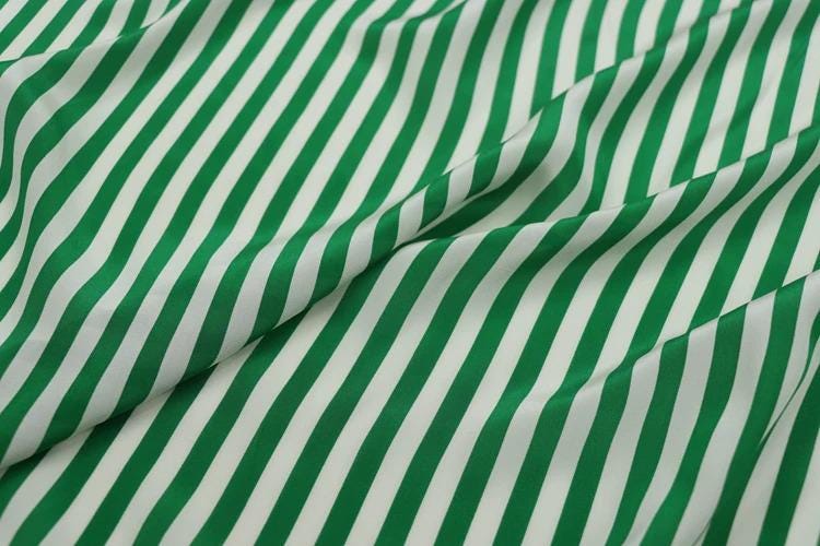 a close-up view of a fabric with a repeating pattern of green and white stripes.