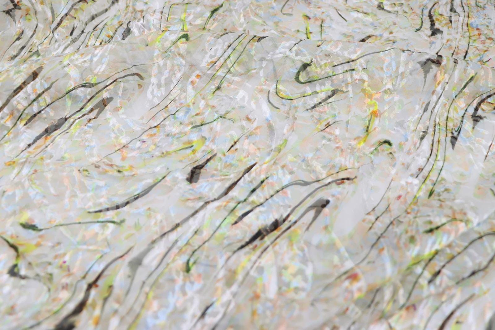 The image is a close-up of a textured surface with a pattern of lines and shapes in various colors, including white, black, and yellow.