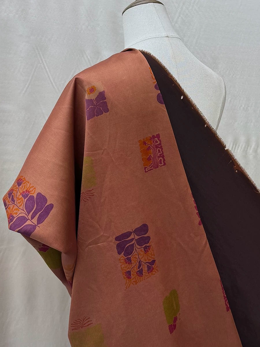 a mannequin wearing a brown and orange patterned fabric with a floral design.