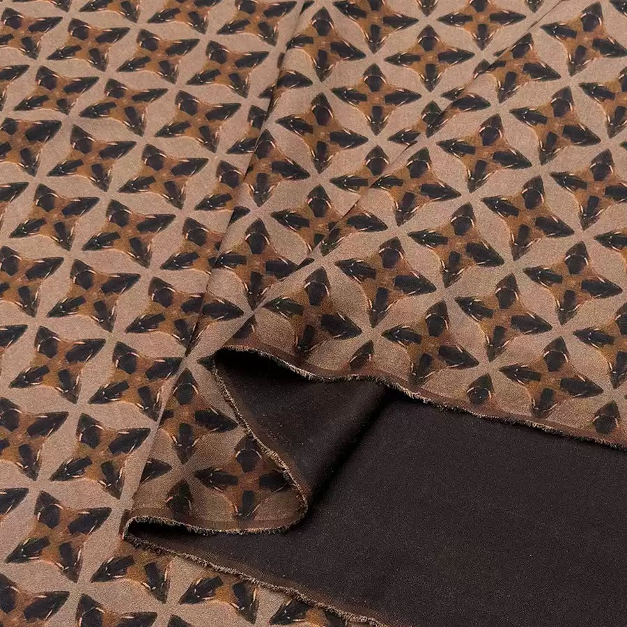 a close-up view of a fabric with a repeating pattern of brown and black geometric shapes, creating a visually striking and intricate design.