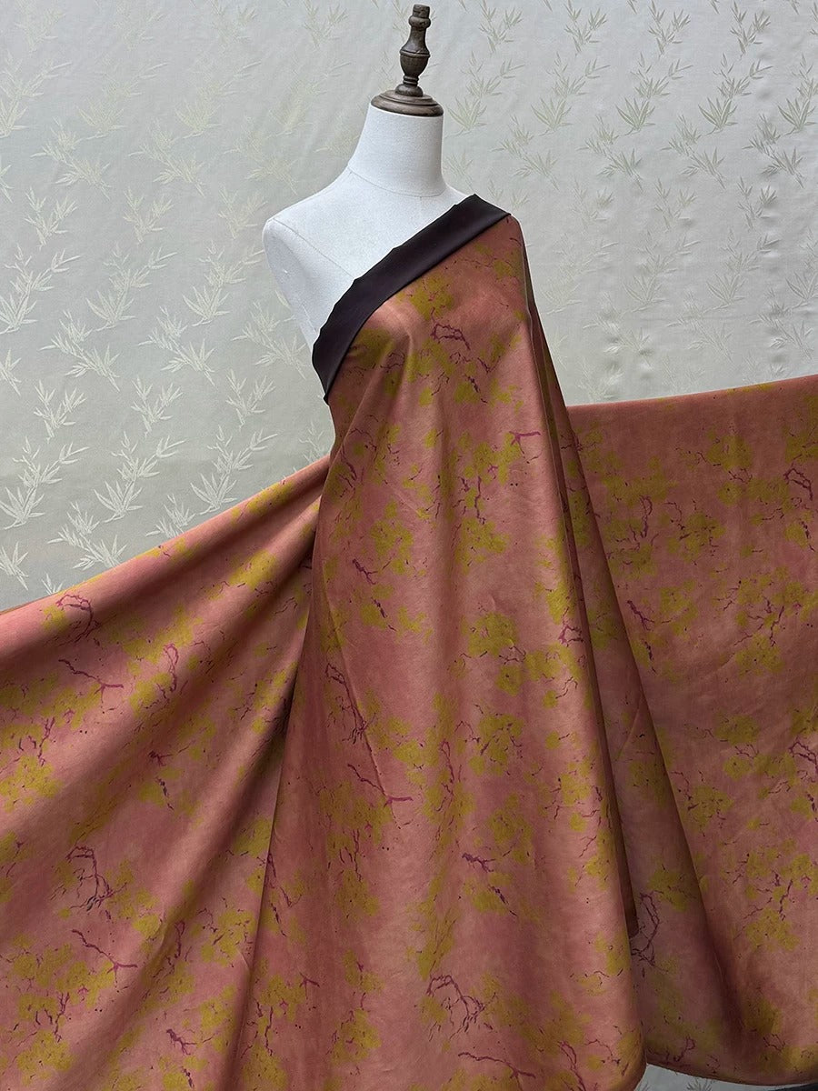 A mannequin wearing a dress with a floral print in shades of pink and yellow.