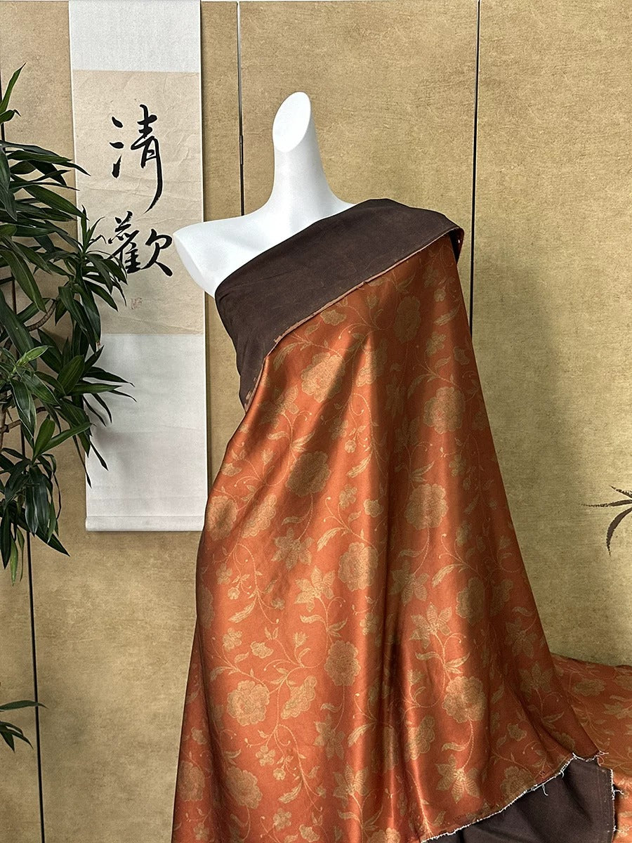 A mannequin wearing a brown and orange floral dress stands in front of a wall with a banner featuring Chinese characters.