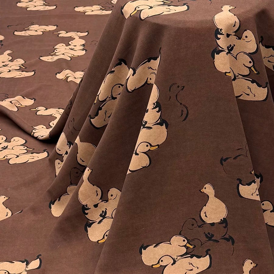a table with a brown table cloth covered with a mickey mouse pattern