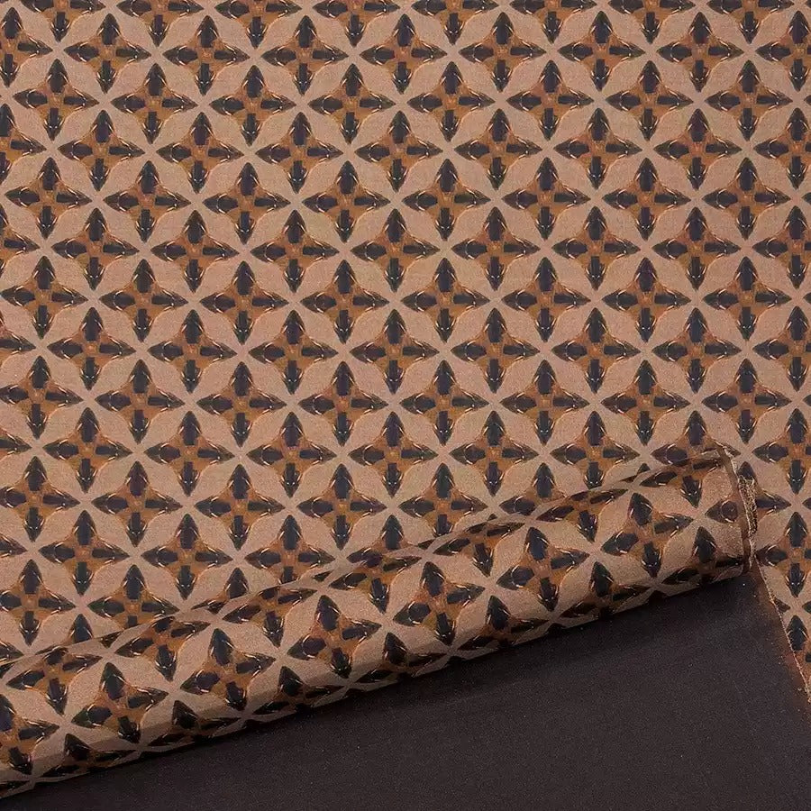 a close-up view of a patterned fabric with a repeating geometric design in shades of brown and black.