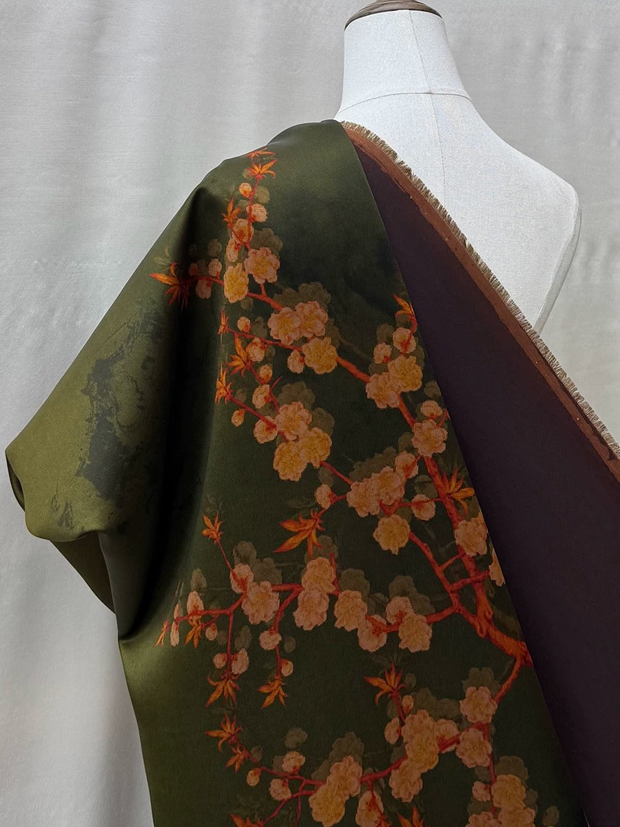 A mannequin wearing a green and brown floral print dress with a dark brown trim.