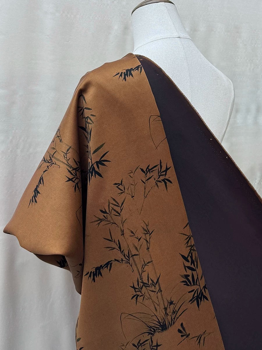 a mannequin wearing a brown and black patterned fabric draped over its shoulder.