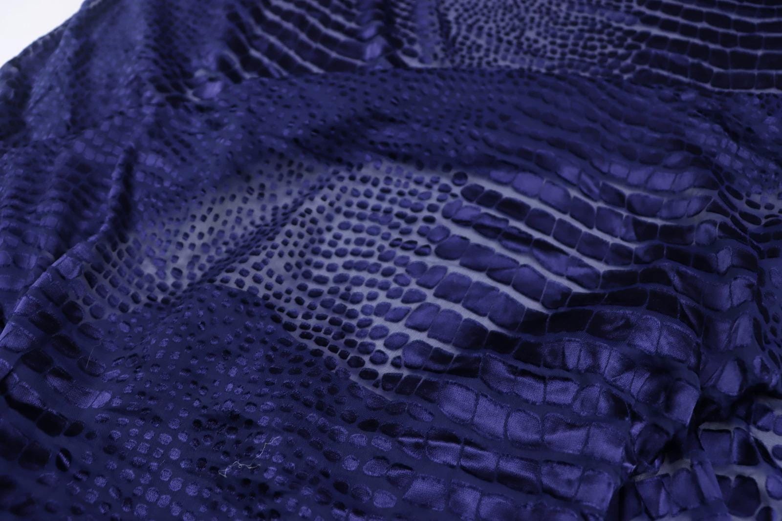 a close-up view of a fabric with a distinctive pattern resembling scales or scales, giving it a textured and visually interesting appearance.