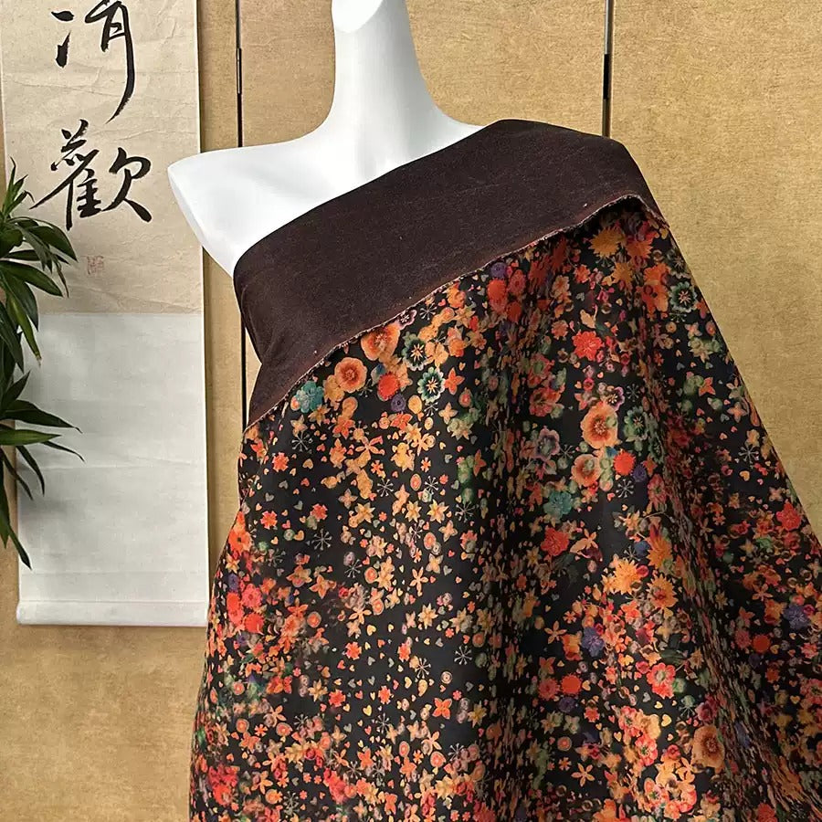 A mannequin wearing a black and brown floral print dress with a brown collar, displayed against a beige wall with a Chinese banner.