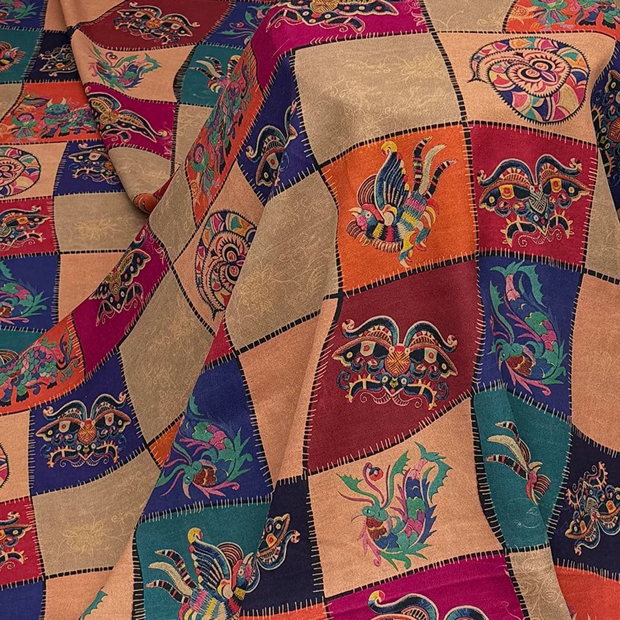 The image is a close-up of a colorful, patchwork fabric with a variety of patterns and designs. The fabric appears to be made of multiple fabric pieces sewn together, creating a visually striking and intricate design.