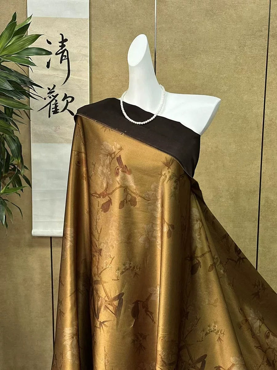 A mannequin wearing a gold and black floral print dress with a pearl necklace, displayed in front of a wall with a Chinese banner.