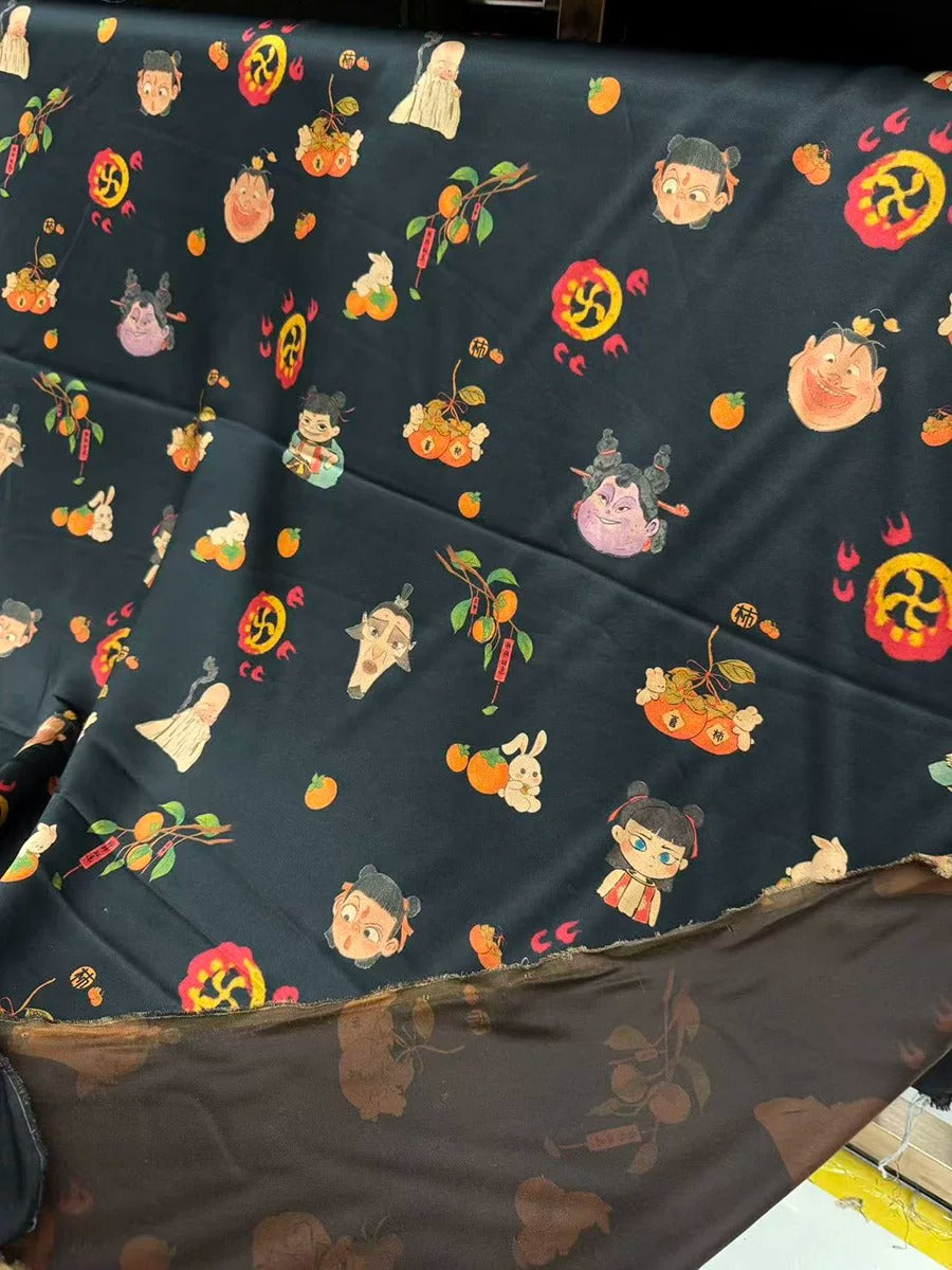 a black fabric with a repeating pattern of various cartoon-like characters and objects, including a cat, a bird, a flower, and a person. The pattern is vibrant and colorful, creating a lively and playful visual effect.