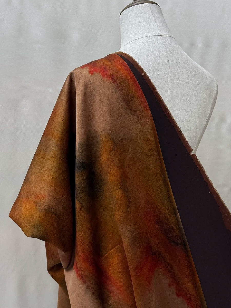 a mannequin wearing a brown and black fabric with a vibrant, abstract pattern.