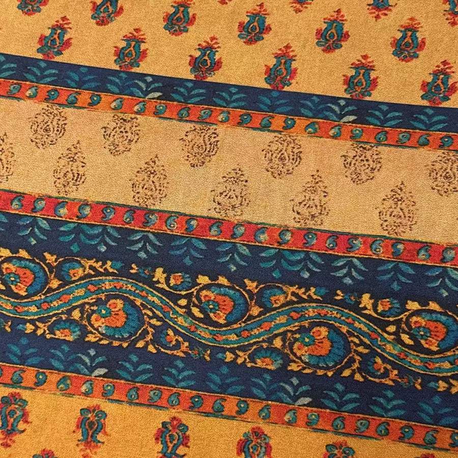 a close-up view of a fabric with a vibrant, colorful, and intricate pattern. The fabric is adorned with a repeating design of floral motifs in shades of blue, orange, and yellow, creating a visually striking and eye-catching pattern. The design is symmetrical, with the flowers and leaves arranged in a repeating pattern across the fabric, adding to the overall aesthetic appeal of the piece.
