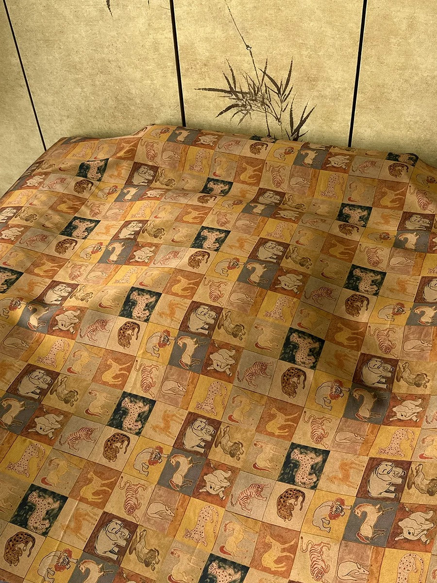 a bed with a colorful, patterned bedspread that includes various animal designs, such as elephants, lions, and zebras. The bedspread is spread out on the bed, creating a visually striking and vibrant display.