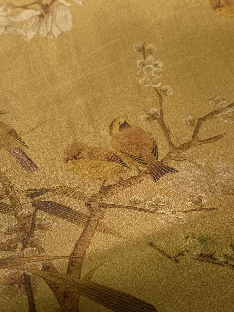 a close-up view of a painting or wallpaper depicting two small birds perched on a branch with white flowers.