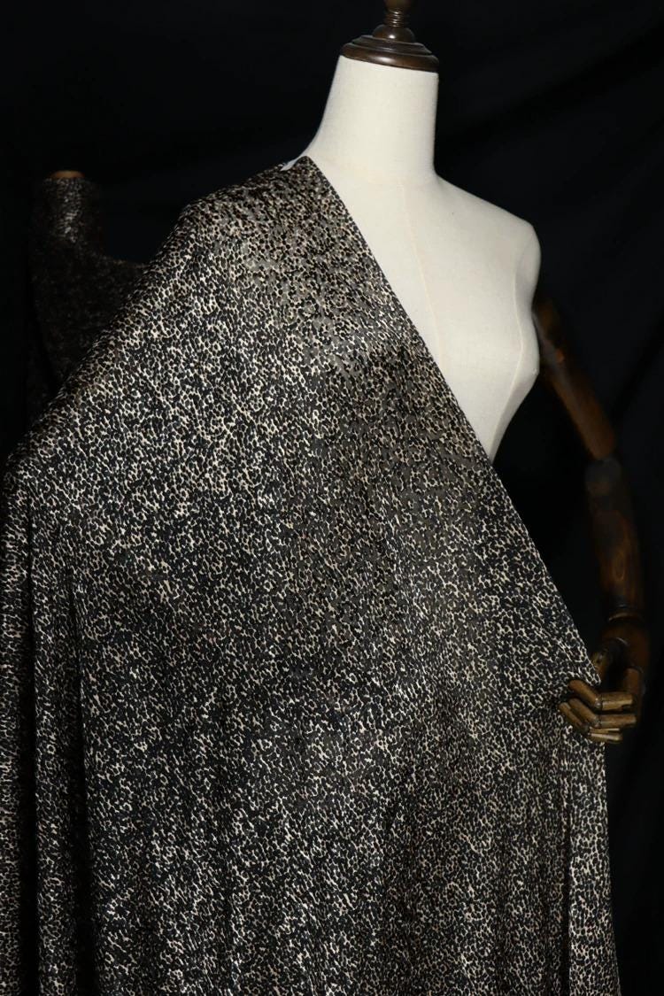 a mannequin wearing a black and white patterned fabric draped over it.