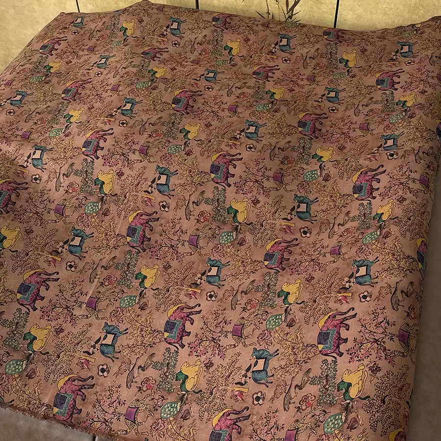 a bed with a colorful, patterned comforter featuring various animal and floral designs.