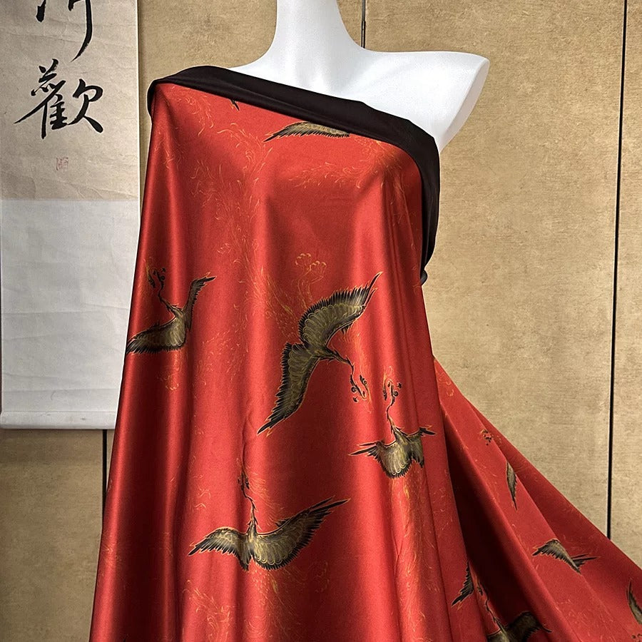A mannequin wearing a red dress with a black and gold crane pattern, displayed against a beige wall with Chinese characters.