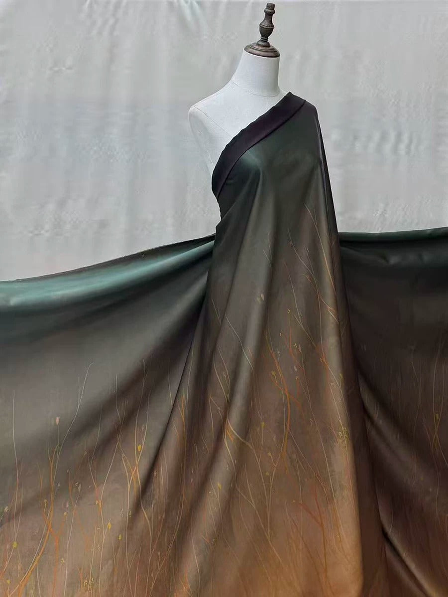 A mannequin wearing a long, flowing dress with a gradient pattern of green and brown colors.