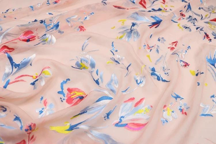 a close-up view of a fabric with a floral pattern in various colors, including pink, blue, and yellow.