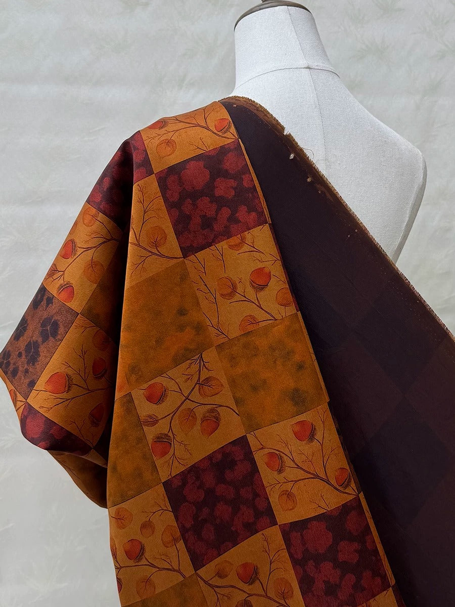 a mannequin wearing a colorful, patterned fabric with a mix of orange, brown, and red colors. The fabric appears to be a quilt or a garment with a patchwork design.