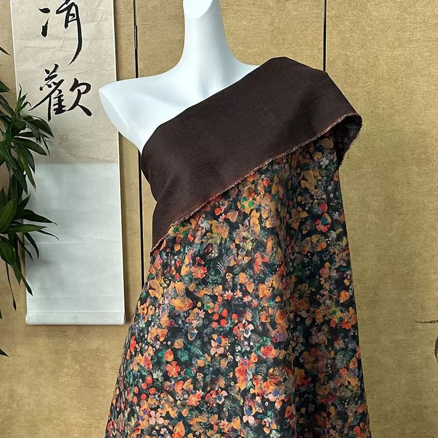 A mannequin wearing a brown fabric with a colorful floral print draped over it, displayed against a beige wall with a Chinese banner.