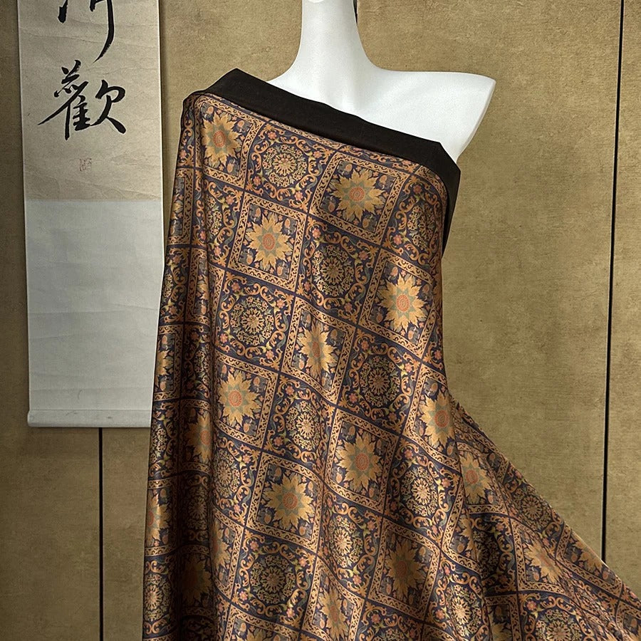 A mannequin wearing a decorative, patterned fabric draped over its body.