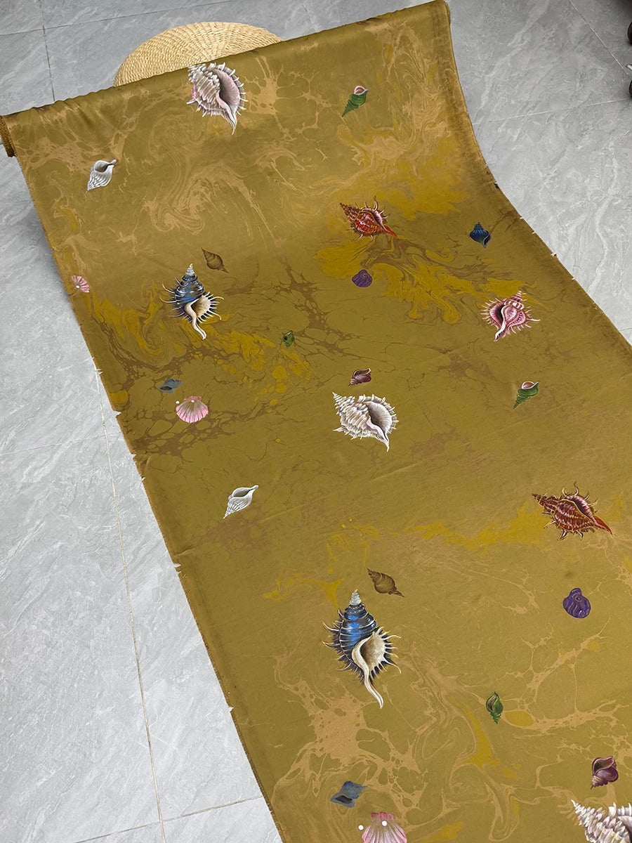 a vibrant, colorful fabric with a repeating pattern of seashells and other marine life. The fabric appears to be a piece of clothing or textile, with the intricate design and the variety of colors creating a visually striking and eye-catching pattern.