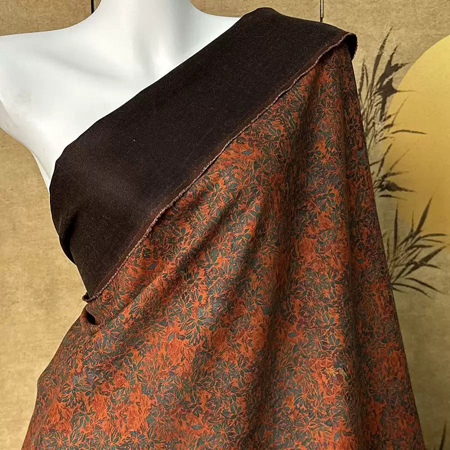 A mannequin wearing a brown and orange floral print dress with a black top.