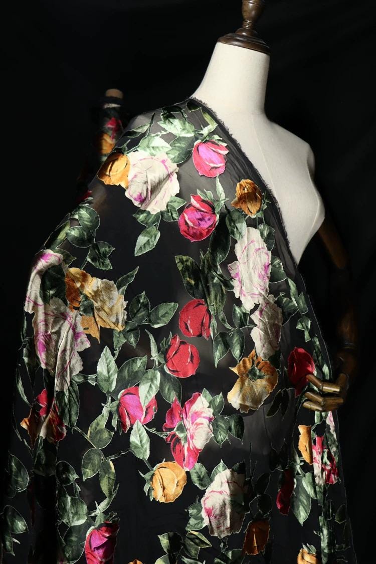 a mannequin wearing a black dress with a colorful floral print.