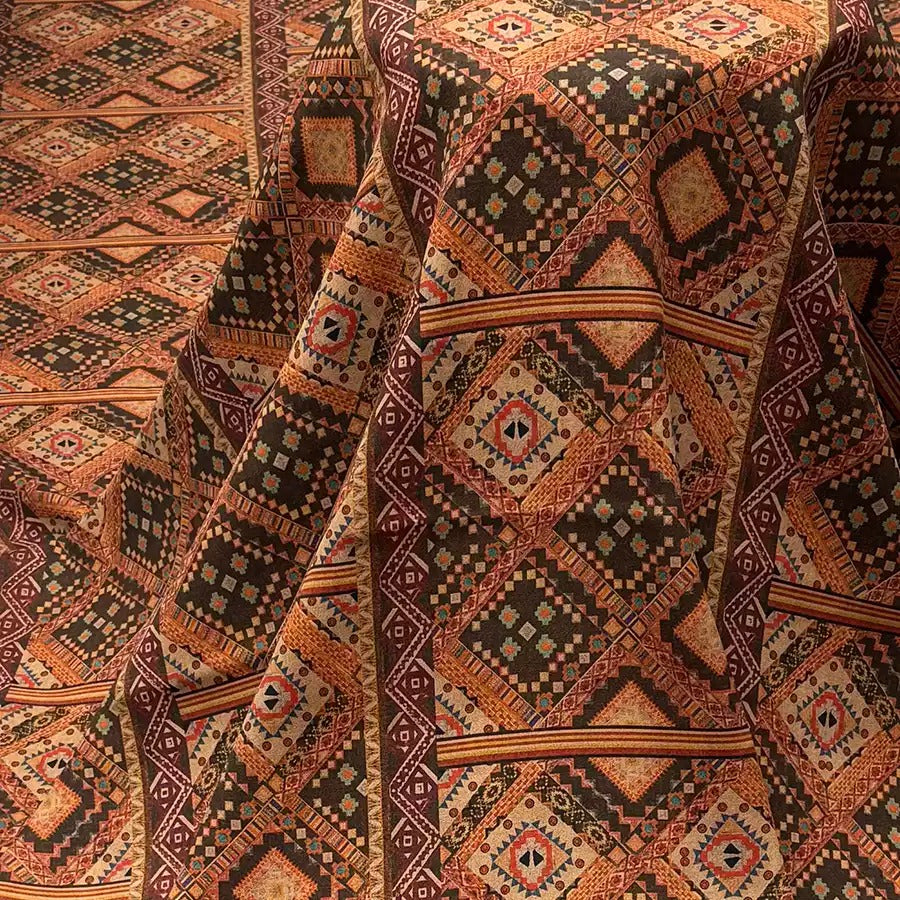 a close-up view of a vibrant, intricately patterned fabric with a geometric design in shades of brown, orange, and black.