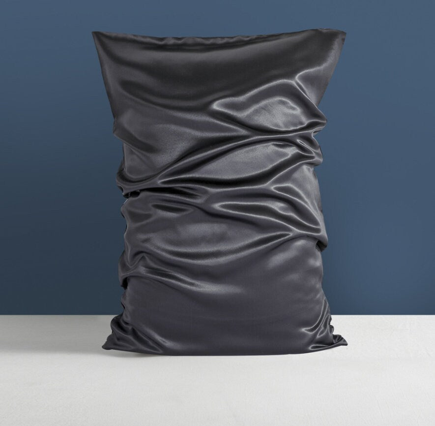 a black pillow with a ruched design on it