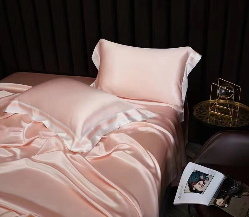 a bed with a pink comforter and pillows
