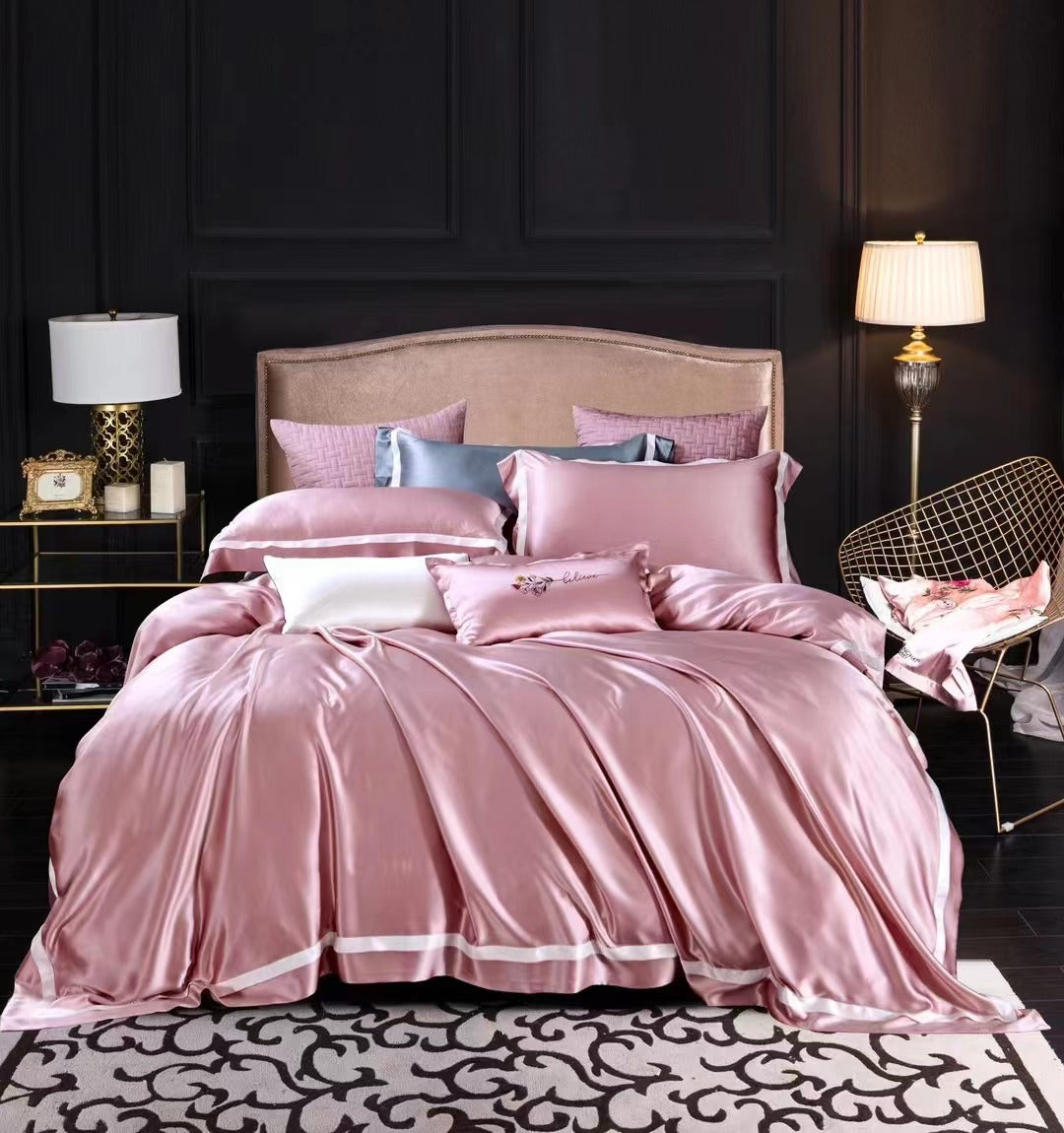 a bed with a pink comforter and pillows