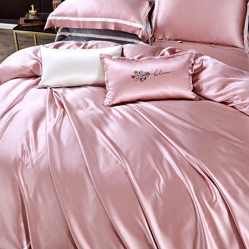 a bed with a pink comforter and pillows