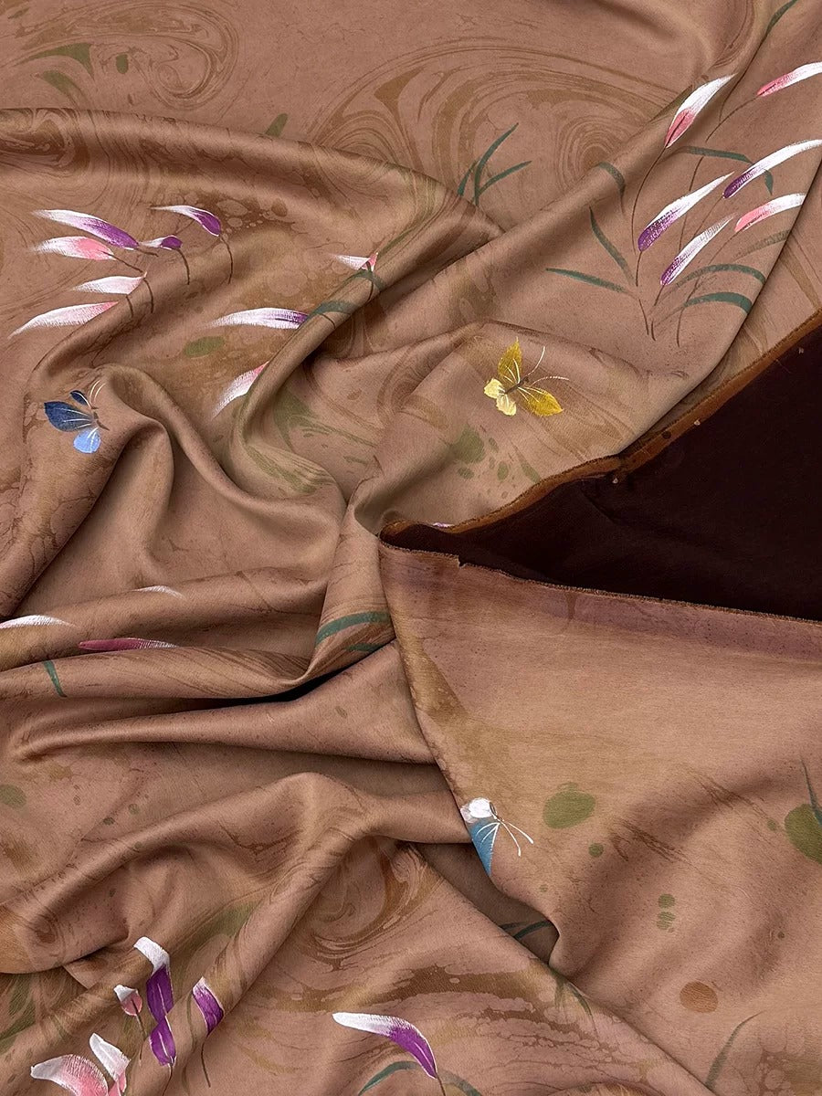 a close-up view of a brown fabric with a floral pattern, featuring a mix of pink, green, and yellow colors. The fabric appears to be crumpled and wrinkled, giving it a textured and soft appearance.