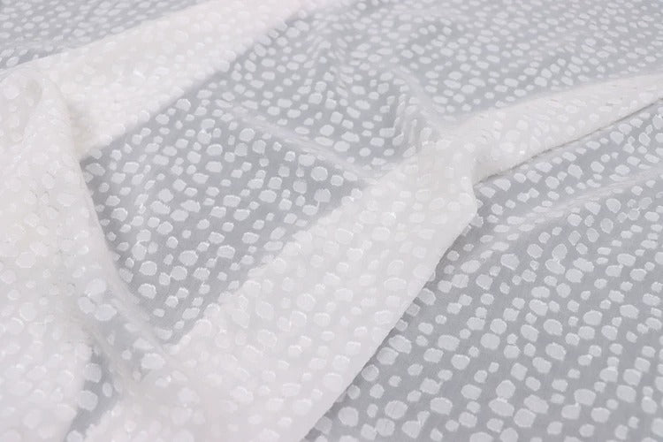 a close-up view of a fabric with a white polka dot pattern.