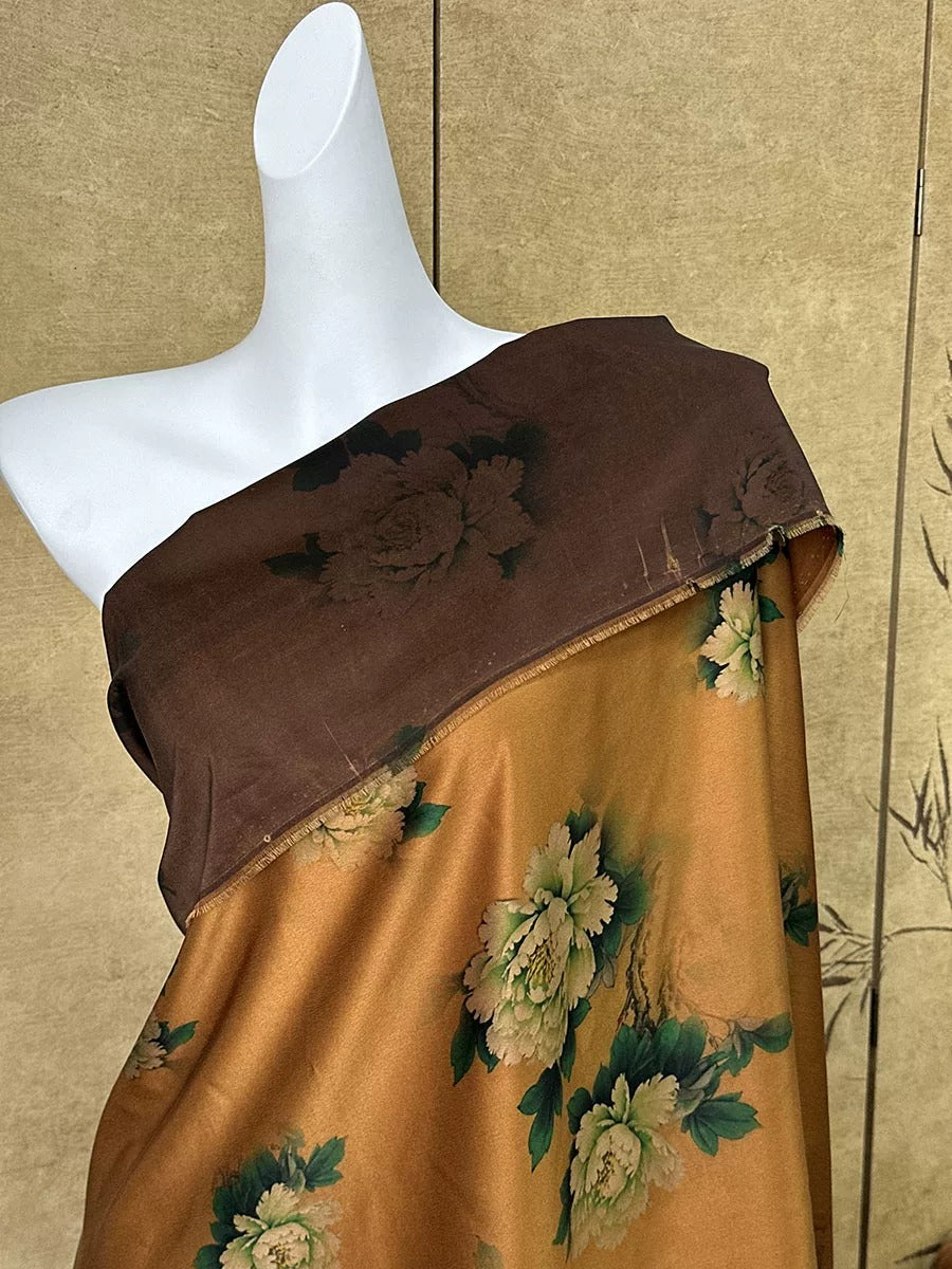 A mannequin wearing a brown and gold floral print dress stands against a beige wall.
