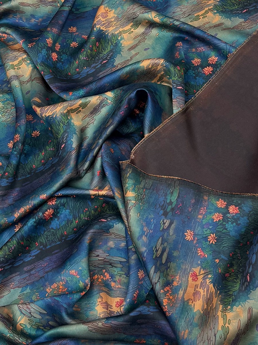 The image is a close-up view of a fabric with a vibrant, colorful floral pattern. The fabric appears to be made of silk or a similar material, and the pattern features a mix of flowers and leaves in various shades of blue, green, and orange. The fabric is crumpled and wrinkled, giving it a textured and dynamic appearance.