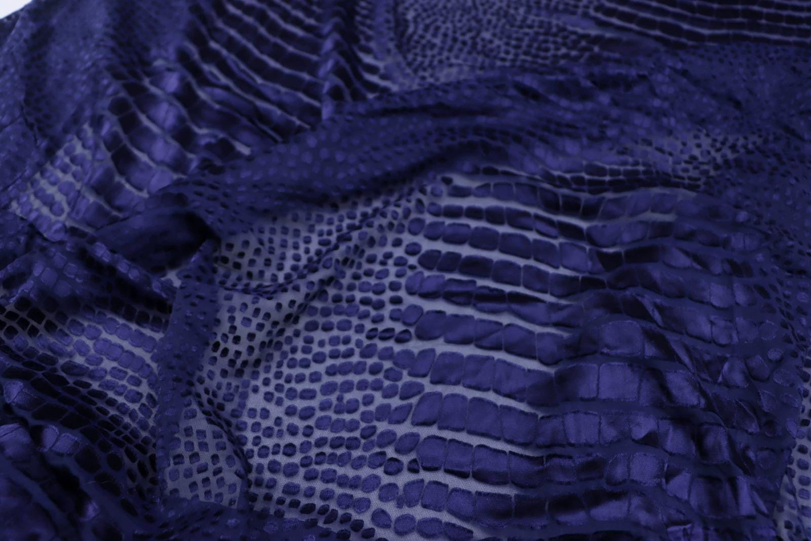 a close-up view of a fabric with a distinctive pattern resembling scales or scales, giving it a textured and visually interesting appearance.